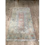 A Middle Eastern rug in pale pink, blue and cream, approx 195cm x 116cm