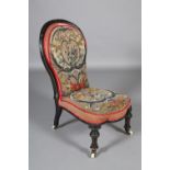 A VICTORIAN EBONISED AND GILT NURSING CHAIR having an encircling frame, original bead and needlework