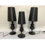 A pair and one black turned table lamps on circular bases with black tapered shades, overall