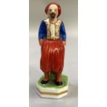 AN EARLY 19TH CENTURY DERBY STEVENSON & HANOCK PORCELAIN FIGURE of a turk, standnng, on plinth