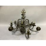 A bronze effect metal twelve light chandelier with scrolled arms from a central baluster column with