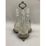 A Victorian cut glass and EPNS triple decanter stand of trefoil outline on pierce bracket feet