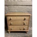 A Victorian revival pine chest of three drawers with turned handles and feet