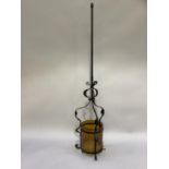 A wrought iron hall light with amber glass shade, base missing