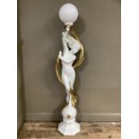 A floor standing figural lamp of naked female holding aloft a white globe entwined with a gilt