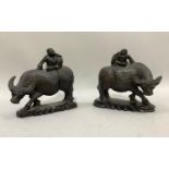 A pair of ebony carvings of a China man sitting on the back of a water buffalo