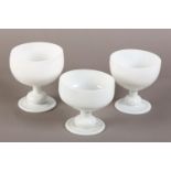 A SET OF THREE BACCARAT WHITE OPALINE PEDESTAL BOWLS, of graduated size, the deep dish on a short