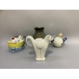 Three novelty teapots including cat, a boat and a skier together with a green glaze jug