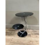 A black glass and chrome two tier occasional table of circular outline