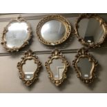 Five gilt framed wall mirrors to include circular with pierced frame, a pair of oval with foliate