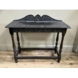 A Victorian carved oak hall table having a short arched raised back, demi lune frieze on turned