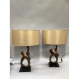 A pair of table lamps of bronze effect resin knot form with pale Cognac coloured oval shades