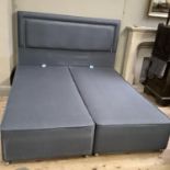 A grey fabric and close nailed padded headboard and two bases, upholstered ensuite with drawers to