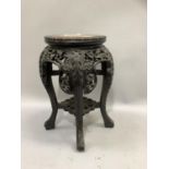 A Chinese hardwood and marble inset urn stand having a carved and pierced apron, on four legs