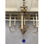 A gilt metal six light chandelier having a coronet and open scrollwork frame with six scrolled