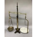 A pair of Victorian brass and cast iron shop scales with brass pan and ceramic platform, the