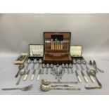 A mahogany canteen of polished stainless steel cutlery and a quantity of loose and cased cutlery
