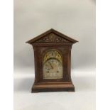 A late 19th century figured walnut mantel clock having a brass dial