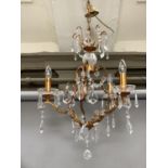 A gilt metal and glass four light chandelier hung with prismatic drops