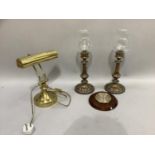 A pair of plated on copper candlestands with glass shades, a brass desk lamp and a mahogany framed