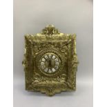 A brass faced wall clock having a face mask and drapery crest, the circular dial with enamelled