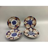 Four Imari plates of circular outline with fluted rims, painted in typical palette