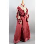 A good late Victorian two-piece costume, in shades of raspberry velvet, the skirt trained, the