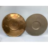 A matched pair of copper chargers each with a well to the middle, approximately 46cm diameter