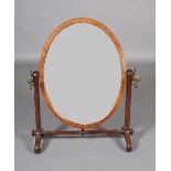 A 19th century mahogany toilet mirror, the oval glass within a chamfered frame, on tapered