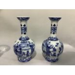 A pair of Delft vases printed in blue and white with canal scenes against a floral ground, 31cm high