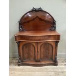 A Victorian mahogany chiffonier having a raised semi-circular back with foliate cresting and angle