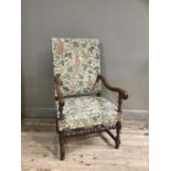 A reproduction oak elbow chair having a tapestry style upholstered back and seat, on turned and
