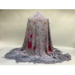 A late 19th century/early 20th century lilac silk shawl, embroidered with large pink flowers and