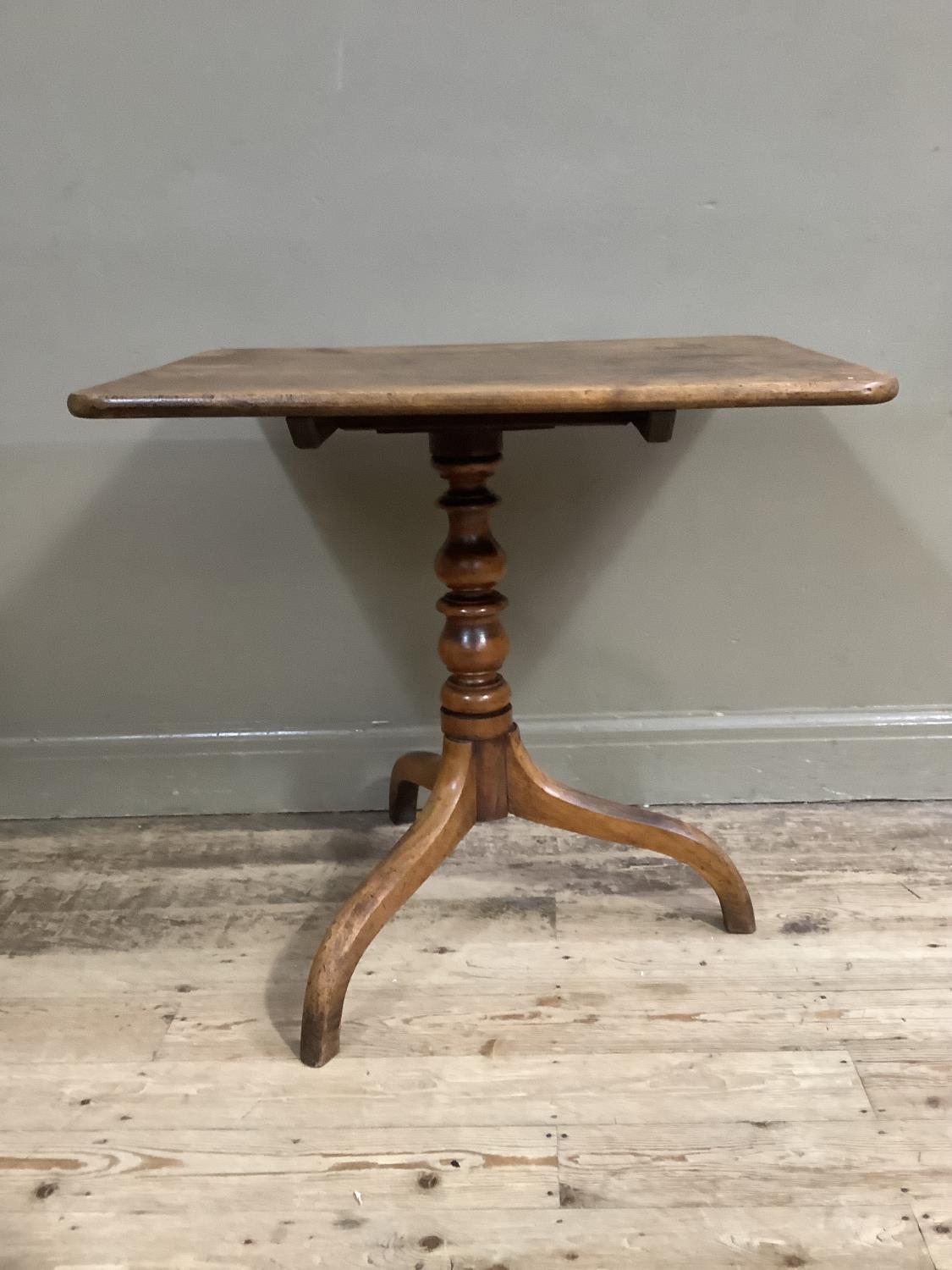 A 19th century mahogany snap top table of rectangular outline on turned column and with tripod base,