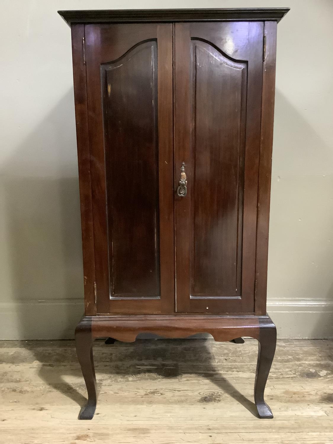 An early 20th century mahogany music cabinet having two doors, the interior fitted with shallow