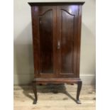 An early 20th century mahogany music cabinet having two doors, the interior fitted with shallow