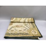 A fine and large Aubusson style needlework carpet, worked in soft green, pink and gold, a rose to