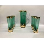 An emerald green glass and gilt lemonade set comprising a tall jug and 6 tumblers.