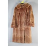 A full-length tan fur coat by “Springs of Blackpool”, possibly mink, with heavy caramel silk lining