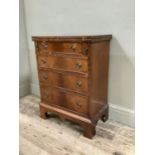 A reproduction mahogany chest of four drawers having a fold out top and on bracket feet, 59cm wide
