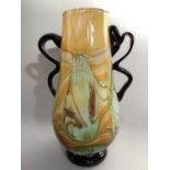 An art glass vase of yellow, green and brown marble effect with black twin scroll handles and