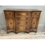 A reproduction mahogany and crossbanded breakfront cabinet having four drawers to the centre flanked