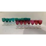 Nine emerald wine glasses and seven cranberry glass wines