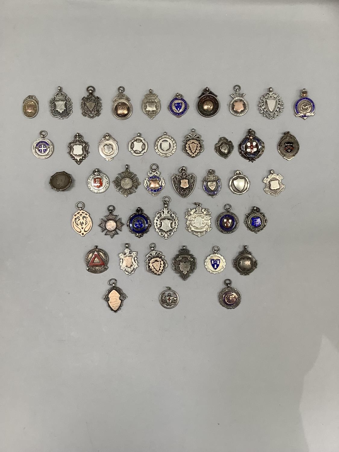 A large collection of 43 early 20th century silver shield shaped watch chain medallions, total