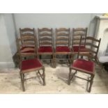 A set of six ladder back dining chairs with red upholstered seats