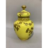 A Royal Crown Derby vase and cover of yellow ground with moulded and gilt trailing flowers, 21cm