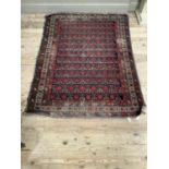 A Middle Eastern rug , the dark blue ground with an all over diamond trellis pattern in red and