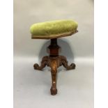 A Victorian walnut revolving piano stool with octagonal seat and on tripod base