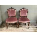 A pair of 19th century mahogany salon chairs with rocaille cresting, pink velvet upholstered back