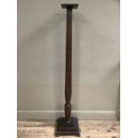 A mahogany reeded torchere on square stepped base